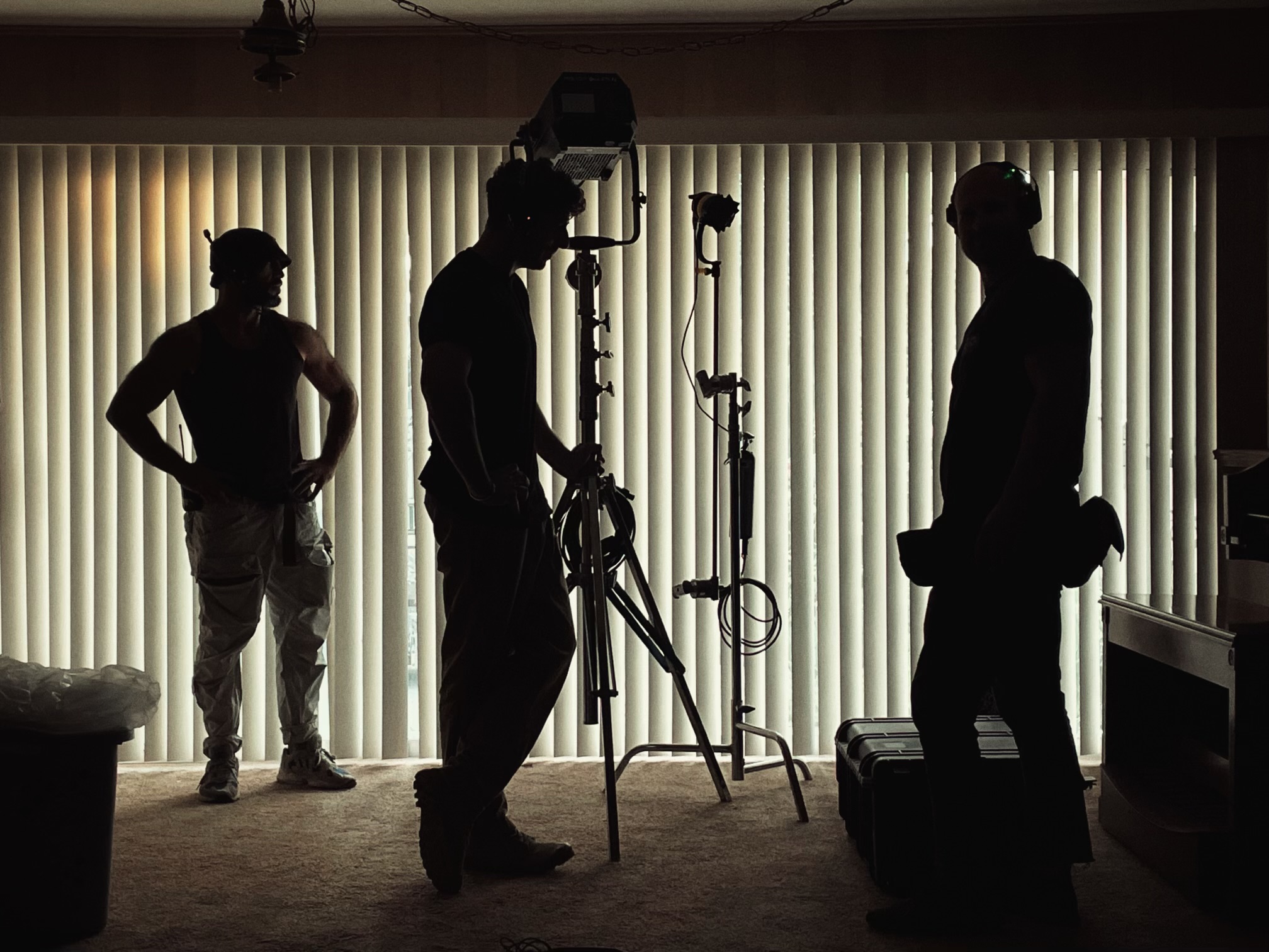 Film crew silhouettes setting up lighting on location Kansas City